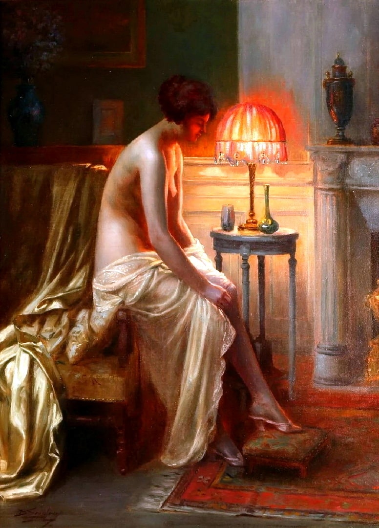 A half-naked woman sitting on the arm of a chair beside a lamp in bedroom.