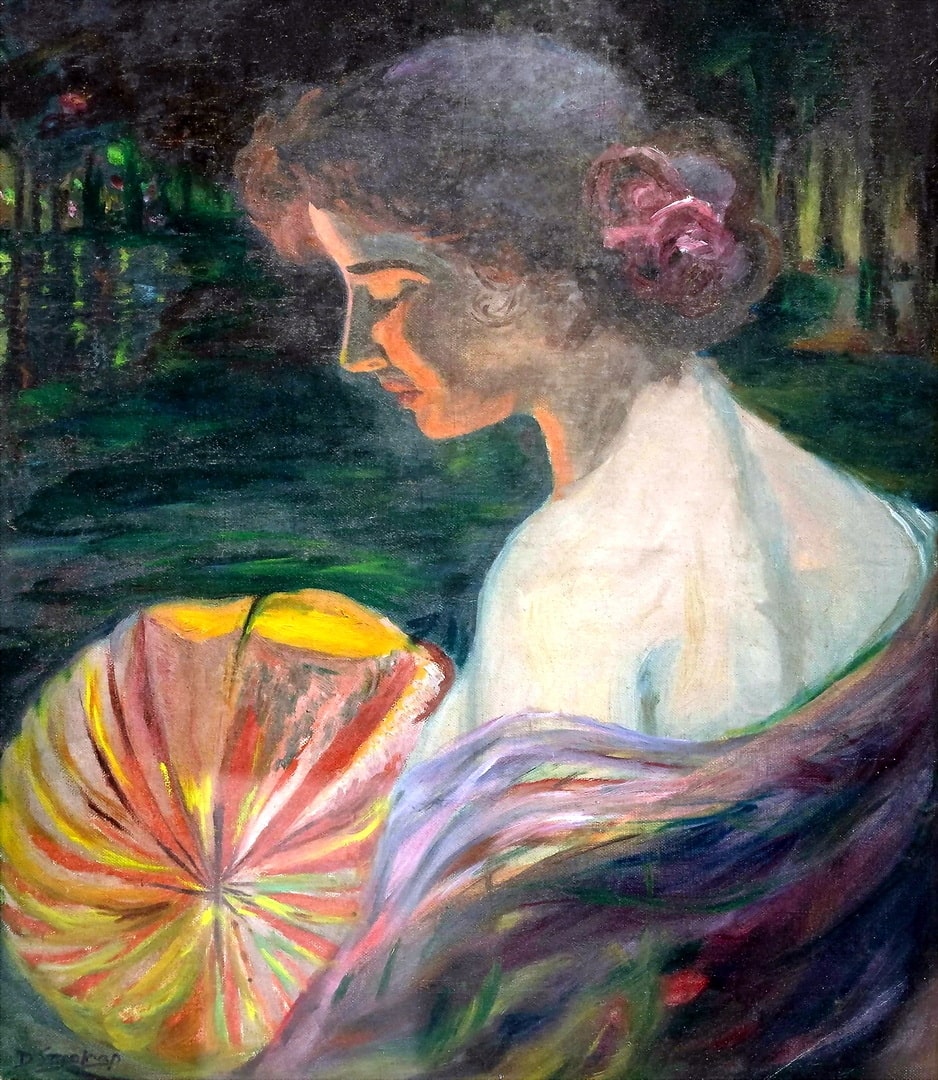 A lady sitting by the lake in an off the shoulder dress and a red flower in her hair and a yellow lantern.