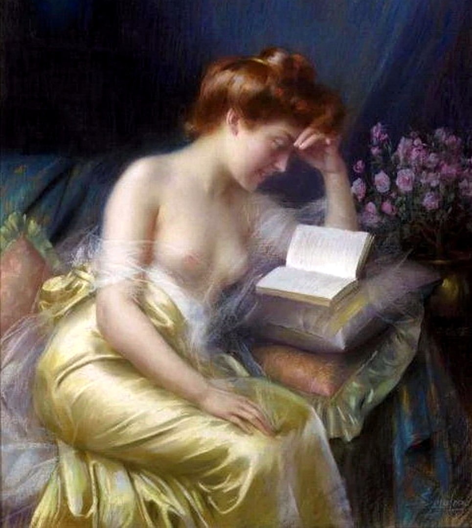 A bare breasted woman readiing a romance story on a couch with some pretty pink flowers in a vase behind her.